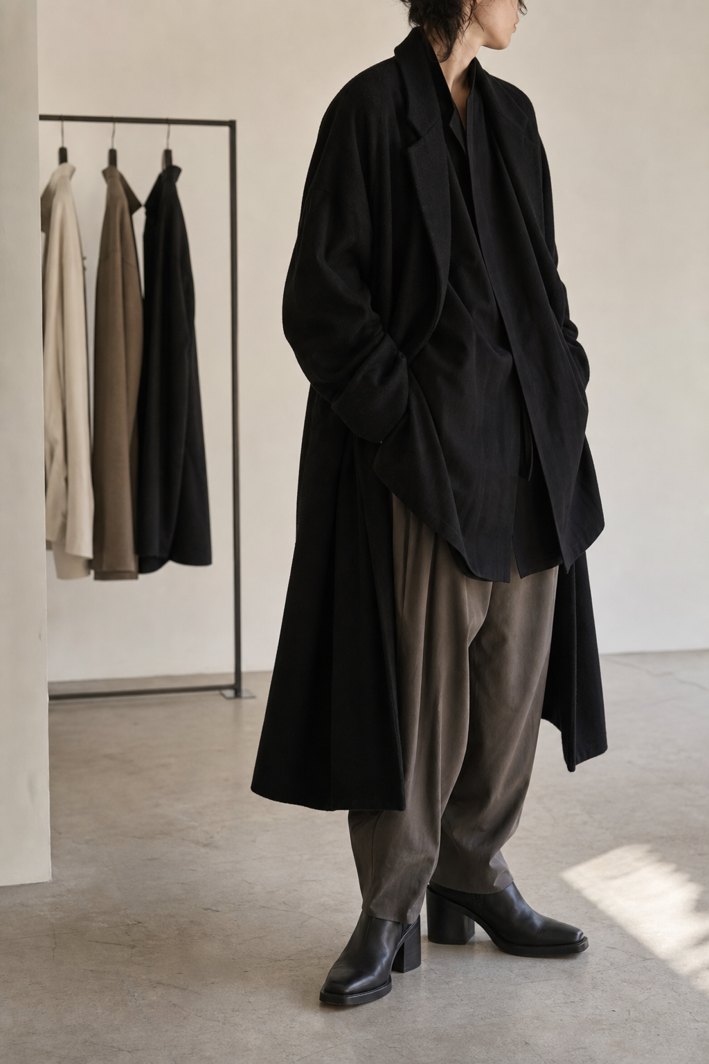 Layered black editorial look inside a quiet fashion studio